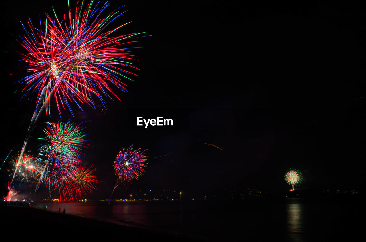 Low angle view of firework display at night