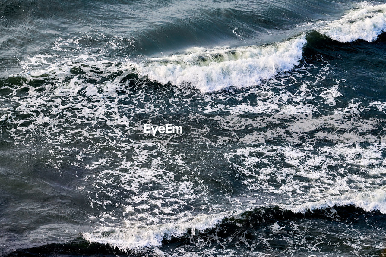 Deep blue sea waters splashing with foamy waves. aerial view of ocean splashing waves, dark blue sea