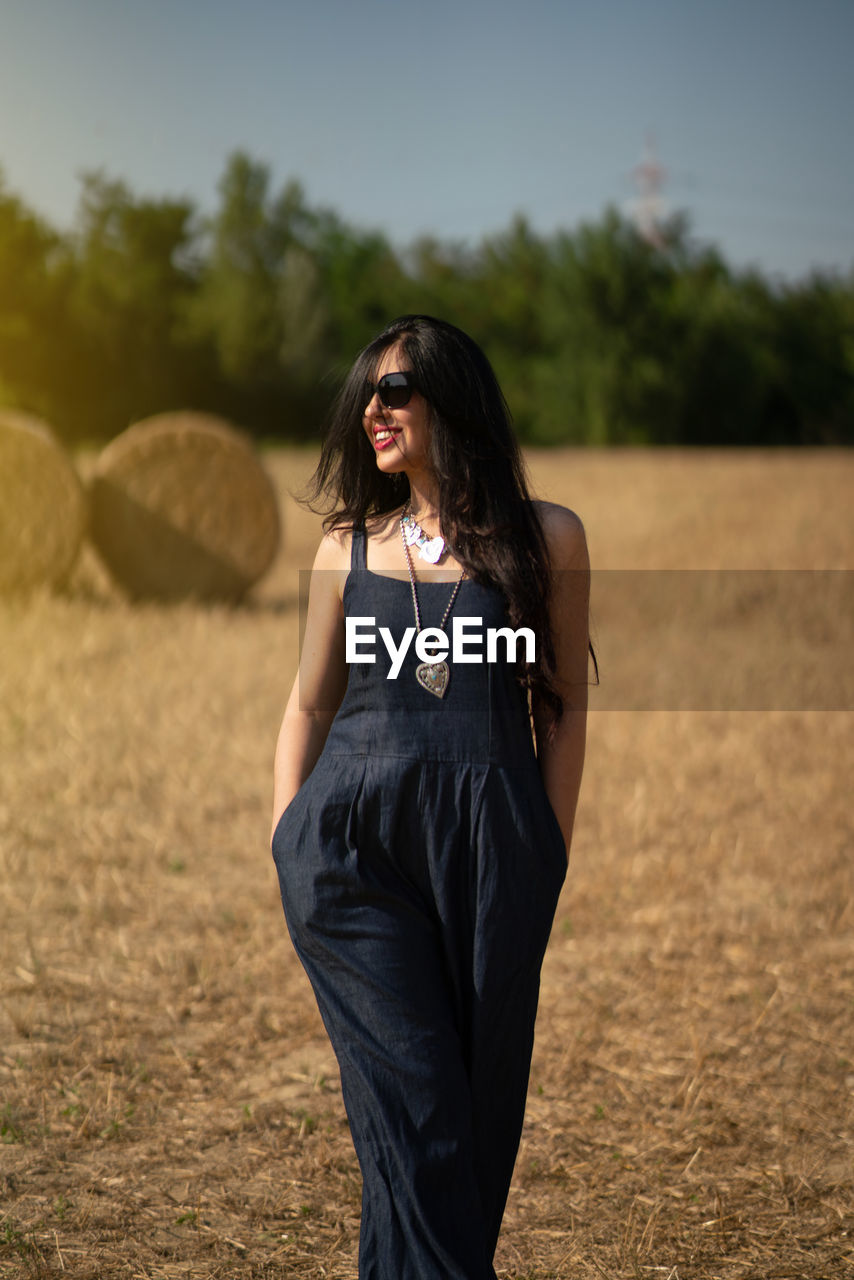 Beautiful fashion woman smile standing on field in summer 