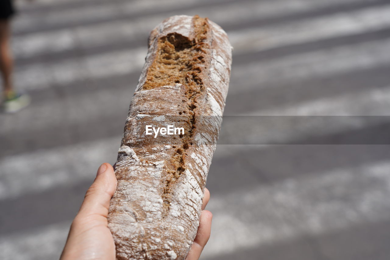 CLOSE-UP OF HAND HOLDING CHOCOLATE CAKE