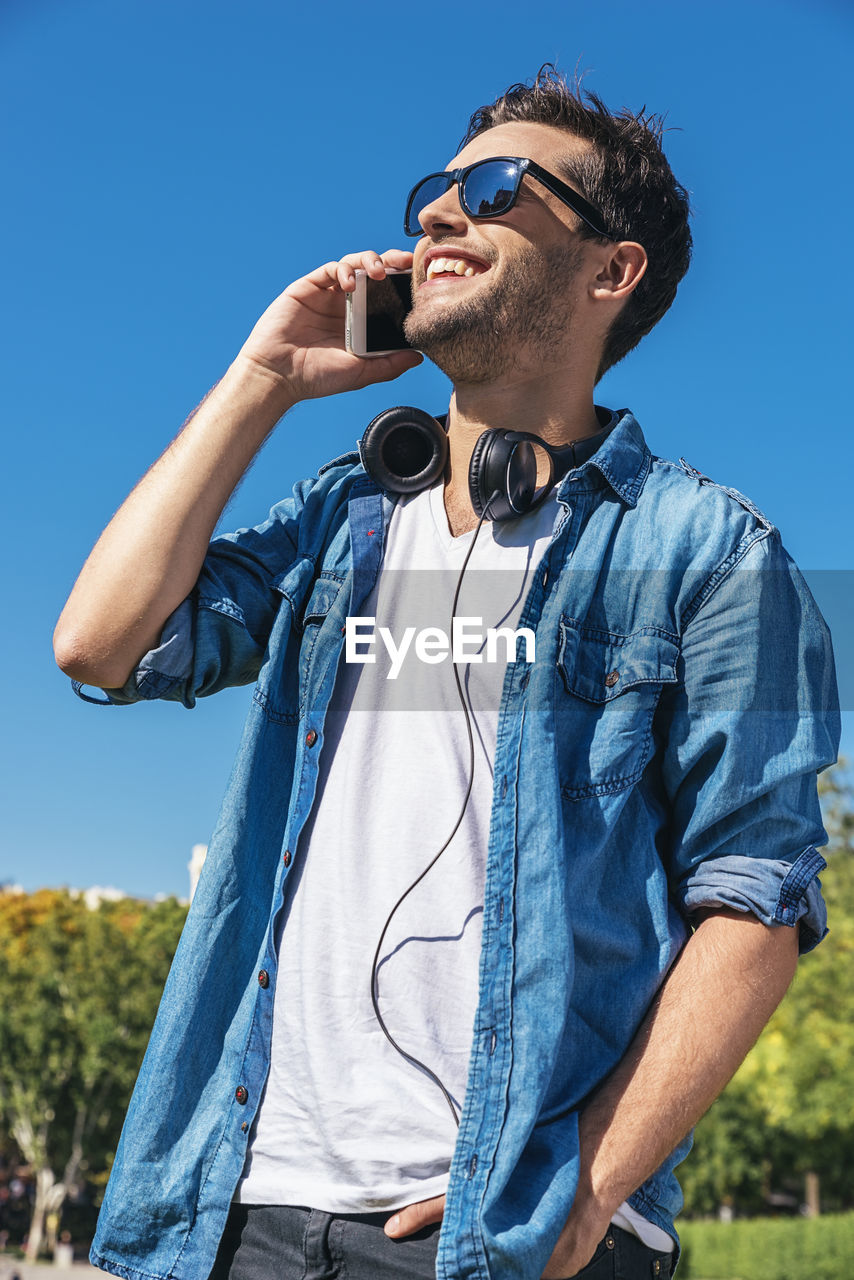 YOUNG MAN WEARING MASK AGAINST CLEAR BLUE SKY