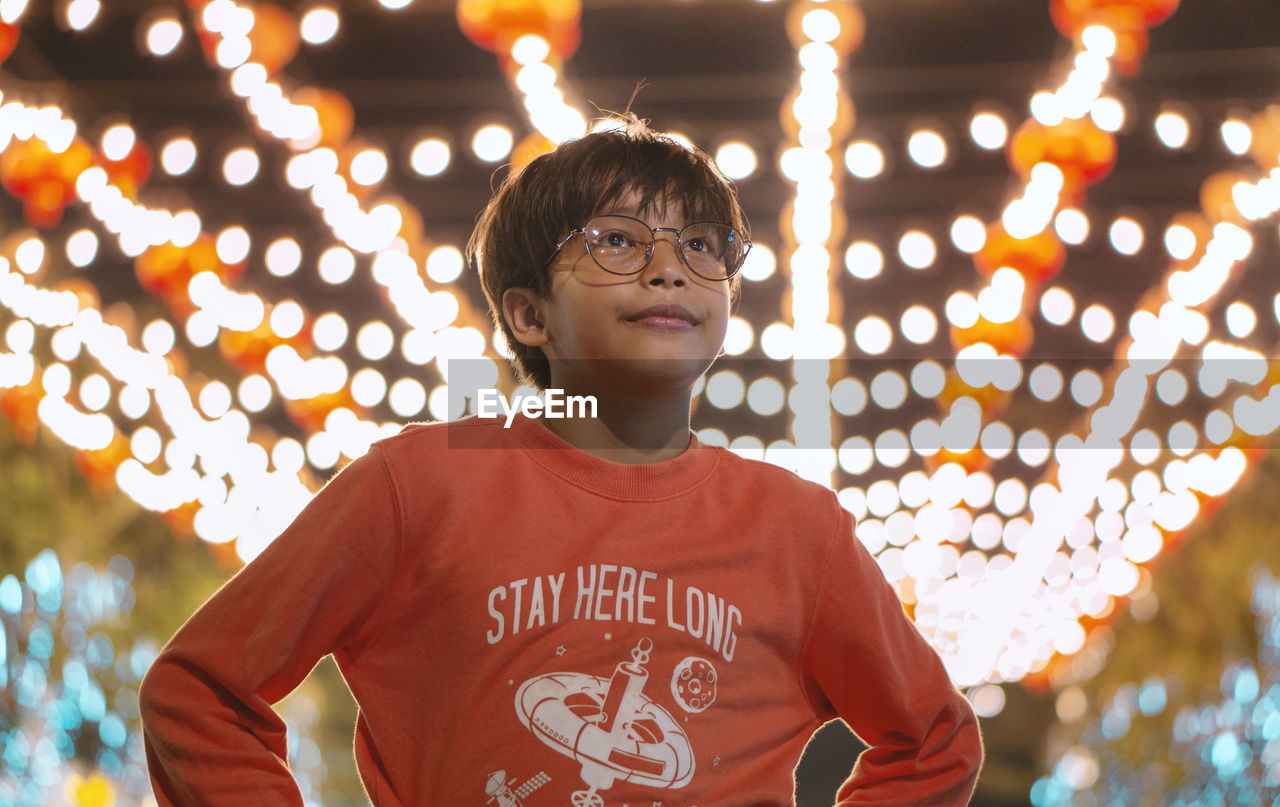 CLOSE-UP PORTRAIT OF BOY WITH ILLUMINATED LIGHTS