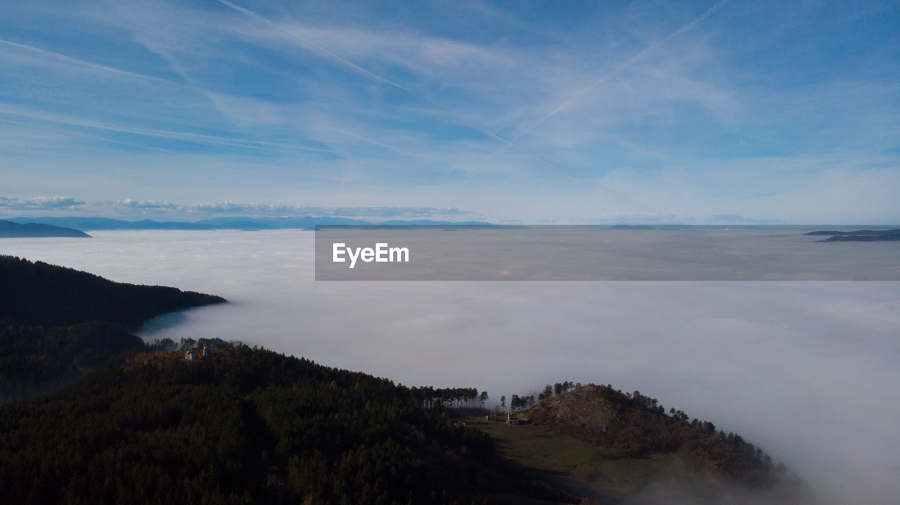 Scenic view of sea and mountains against blue sky