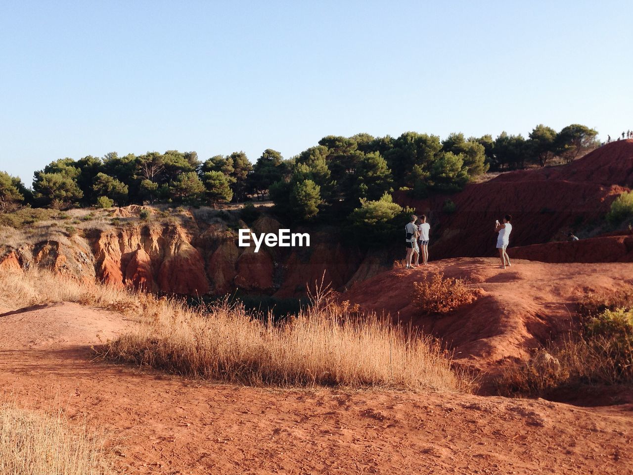 Tourists in desert against clear sky