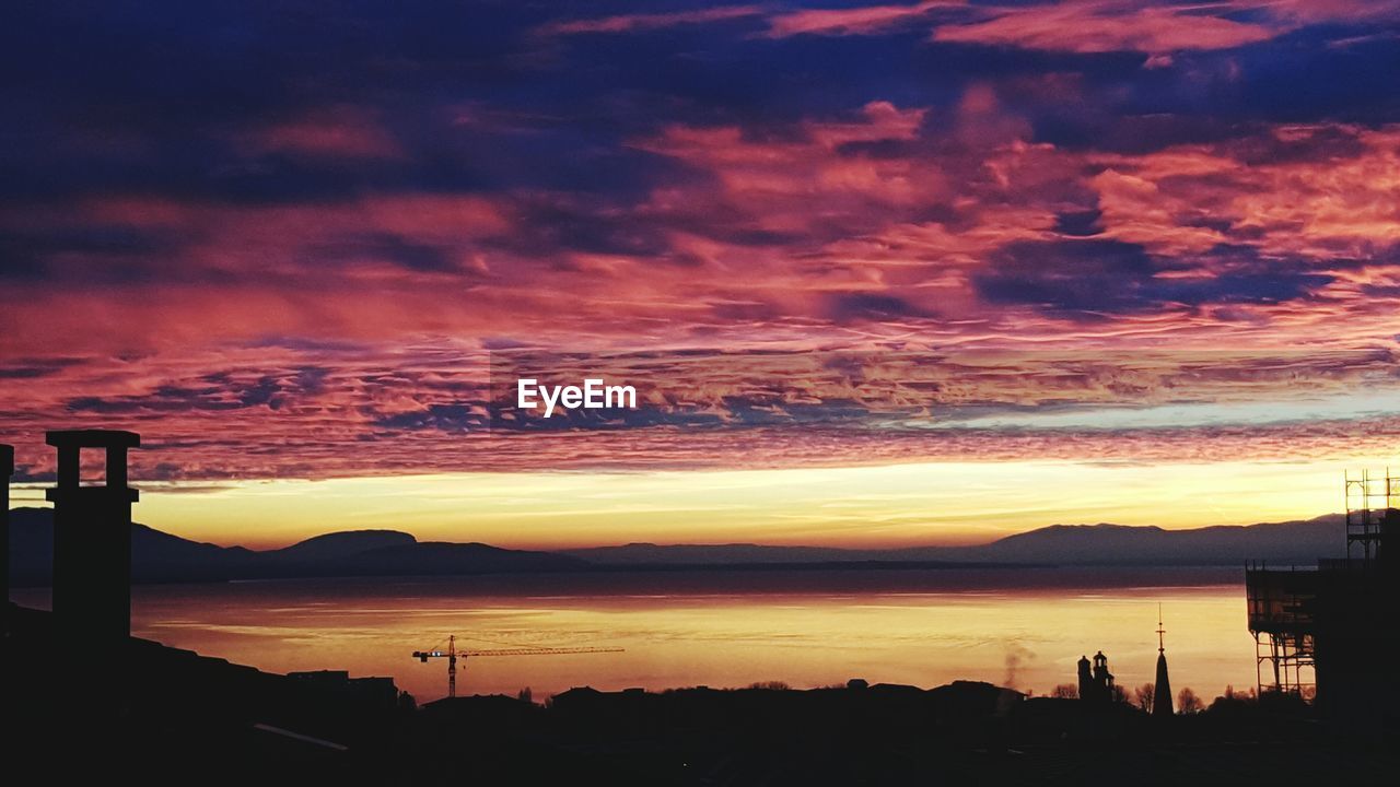 SILHOUETTE OF MOUNTAINS AGAINST CLOUDY SKY