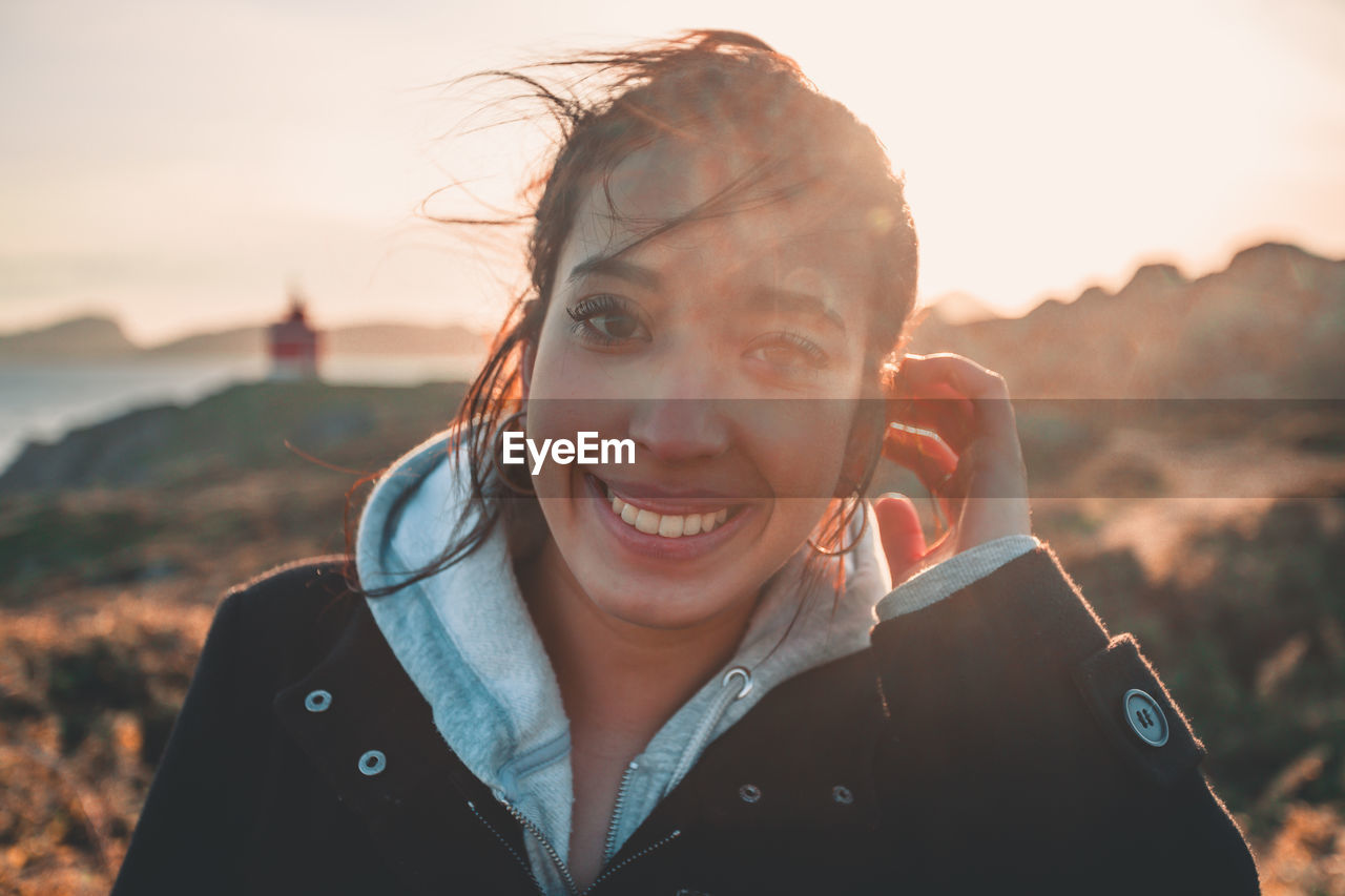 Portrait of young woman against sky