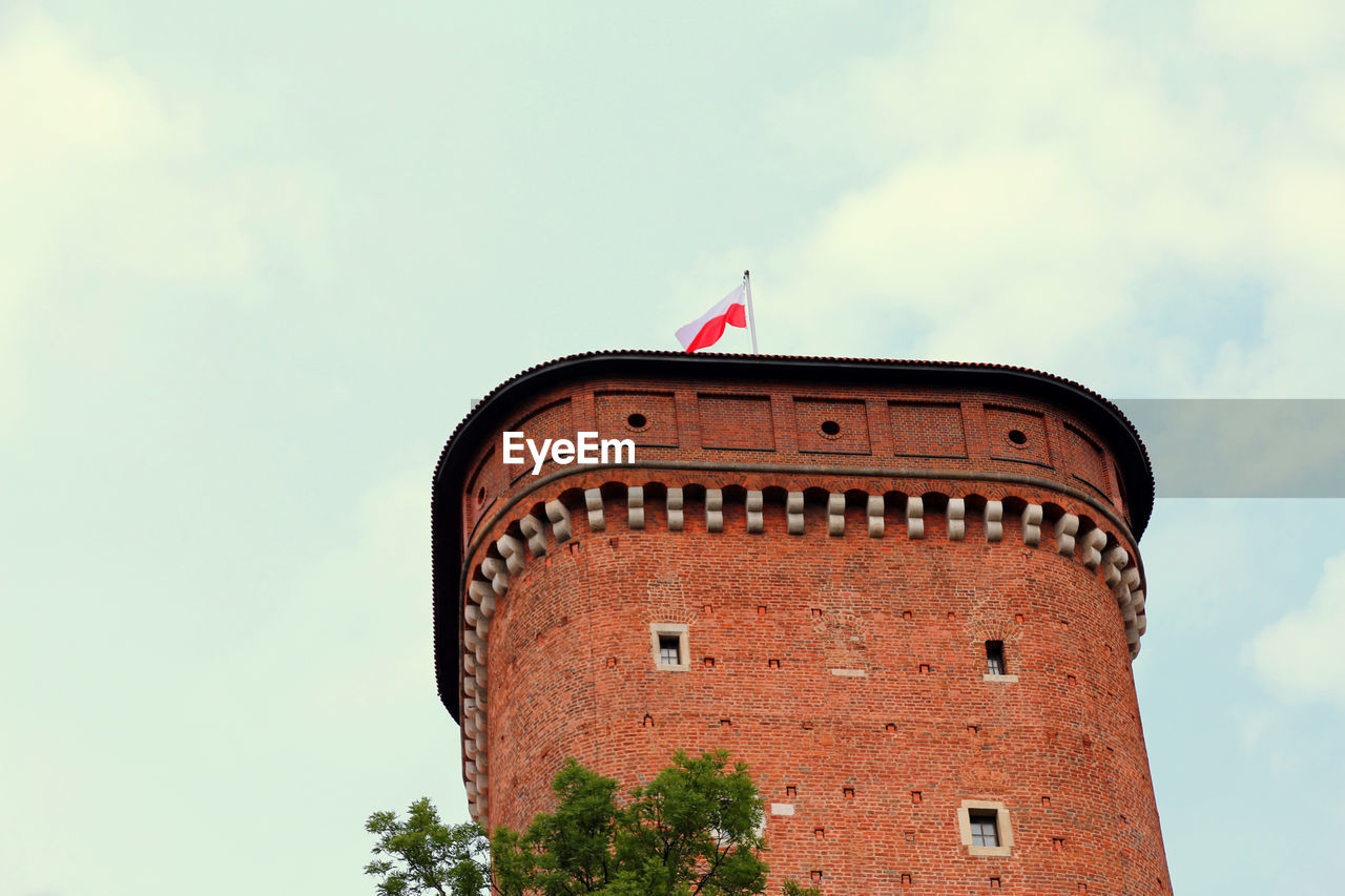 Tower of castle wawel in krakow in poland anf the national flag