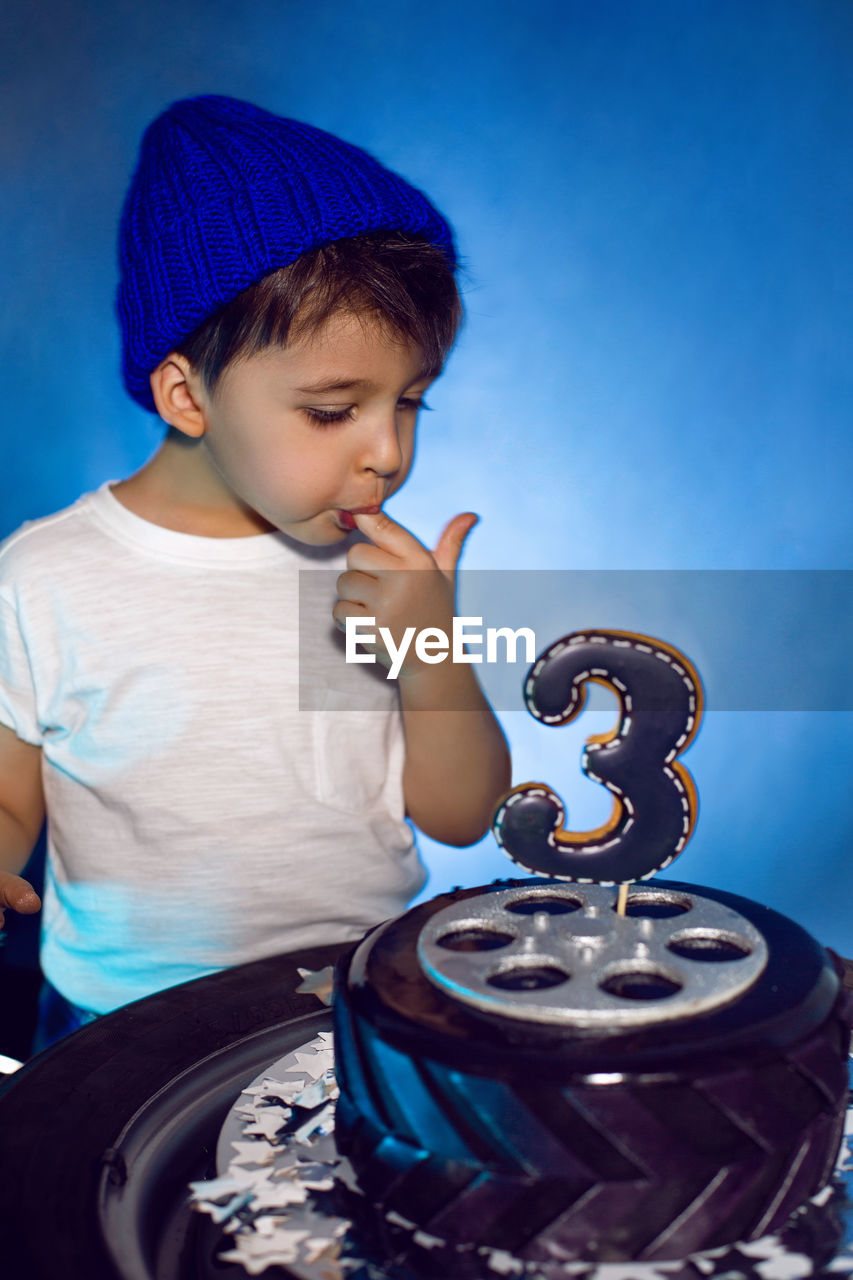 Baby boy eats his birthday cake in the form of a wheel in the studio