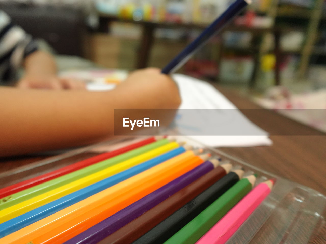 multi colored, indoors, pencil, writing, one person, creativity, education, close-up, selective focus, art, craft, learning, hand, focus on foreground, adult, occupation, colored pencil, book, publication, table
