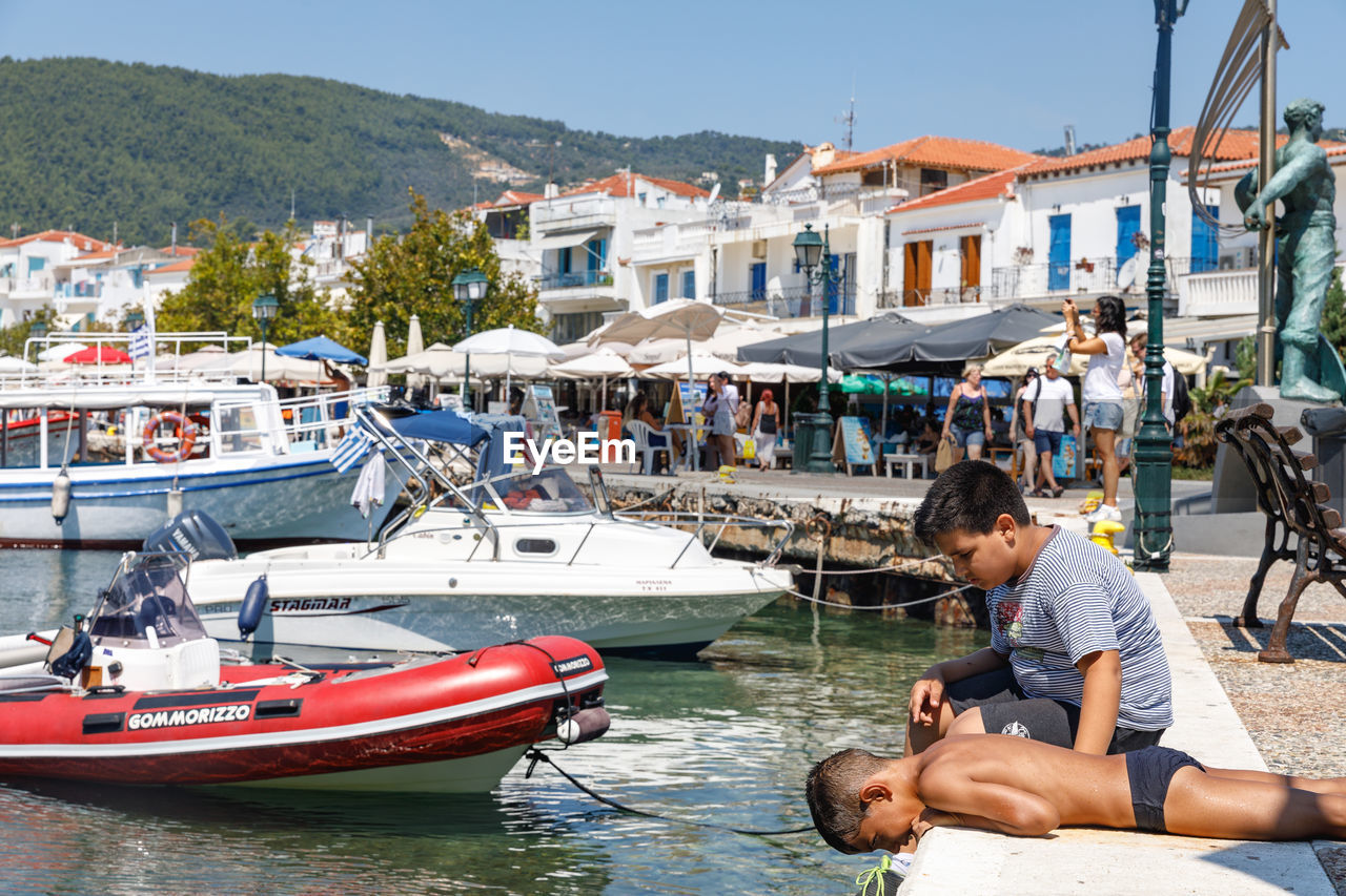 PEOPLE ON BOAT AGAINST BUILDINGS