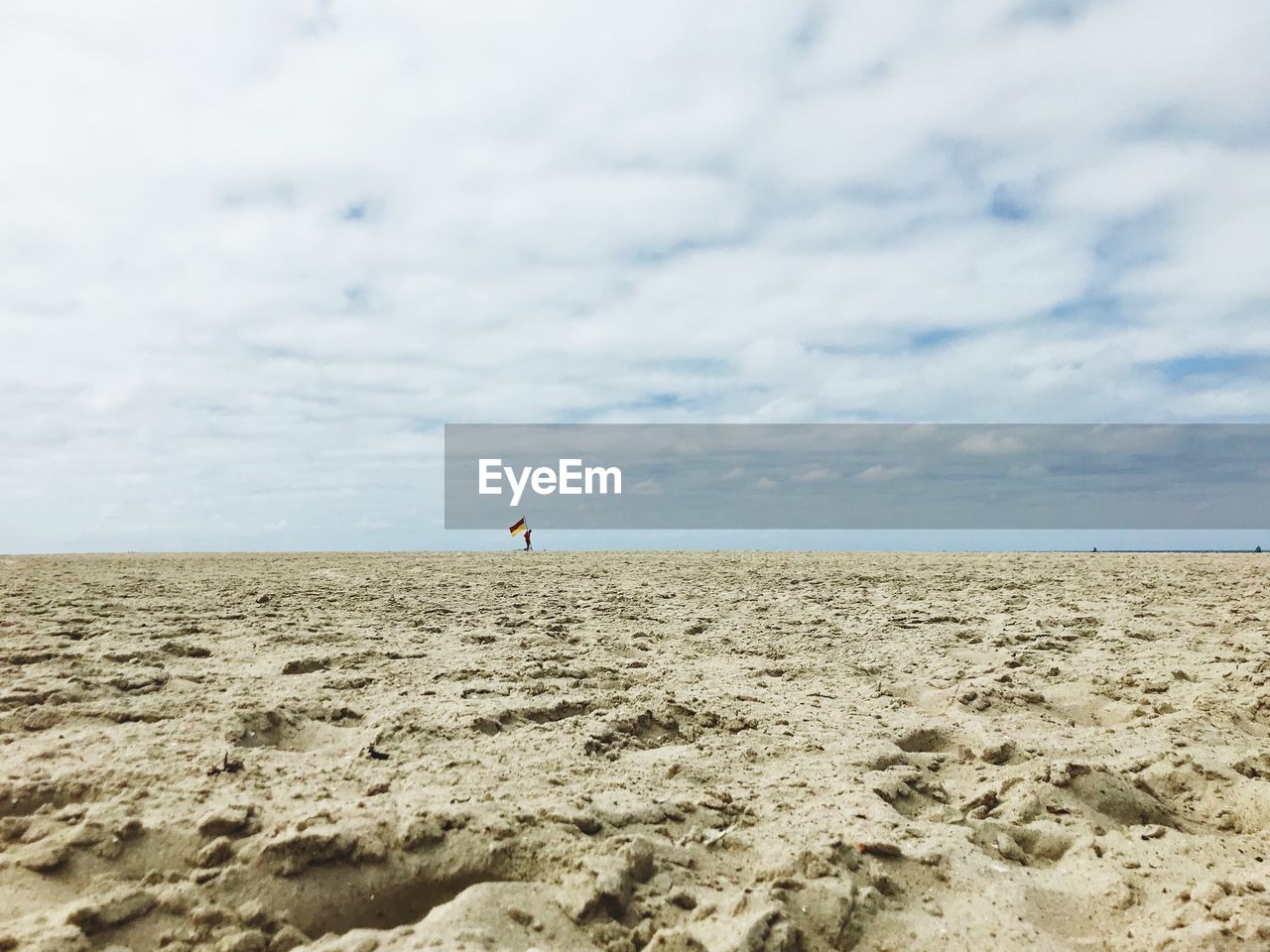 Scenic view of beach against cloudy sky