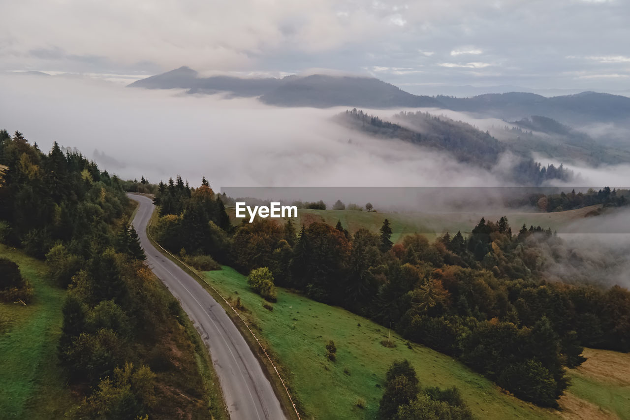 Beautiful misty foggy morning in mountains with fog on the hills. early autumn. aerial drone view