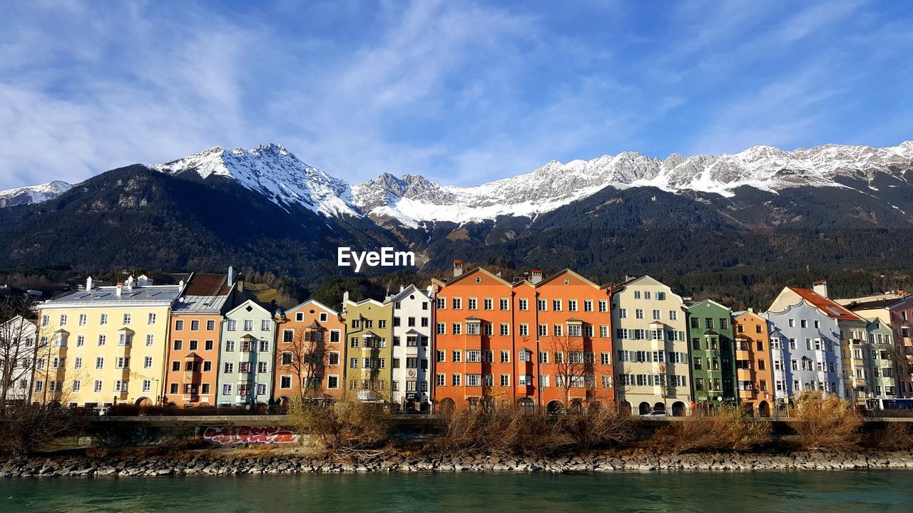 Buildings by mountains against sky during winter