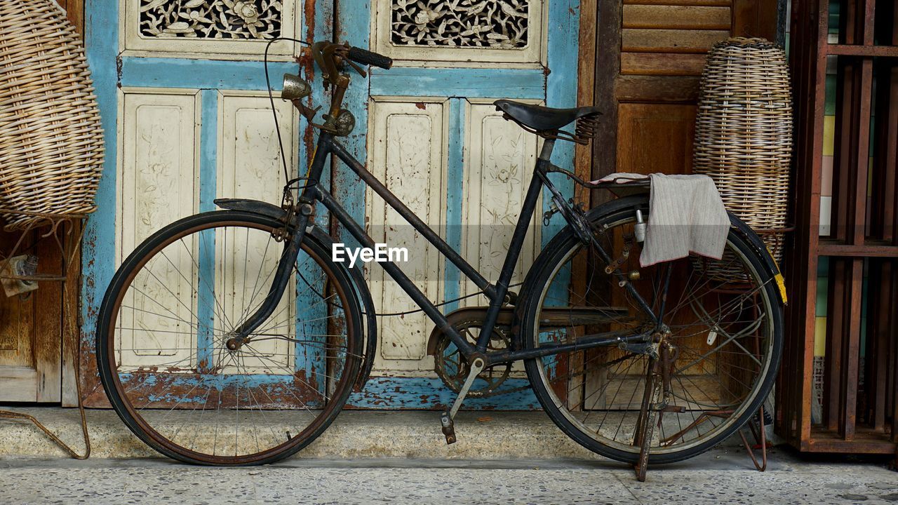 BICYCLE LEANING AGAINST BRICK WALL