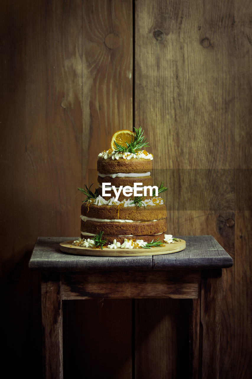 Cake on wooden table against wall