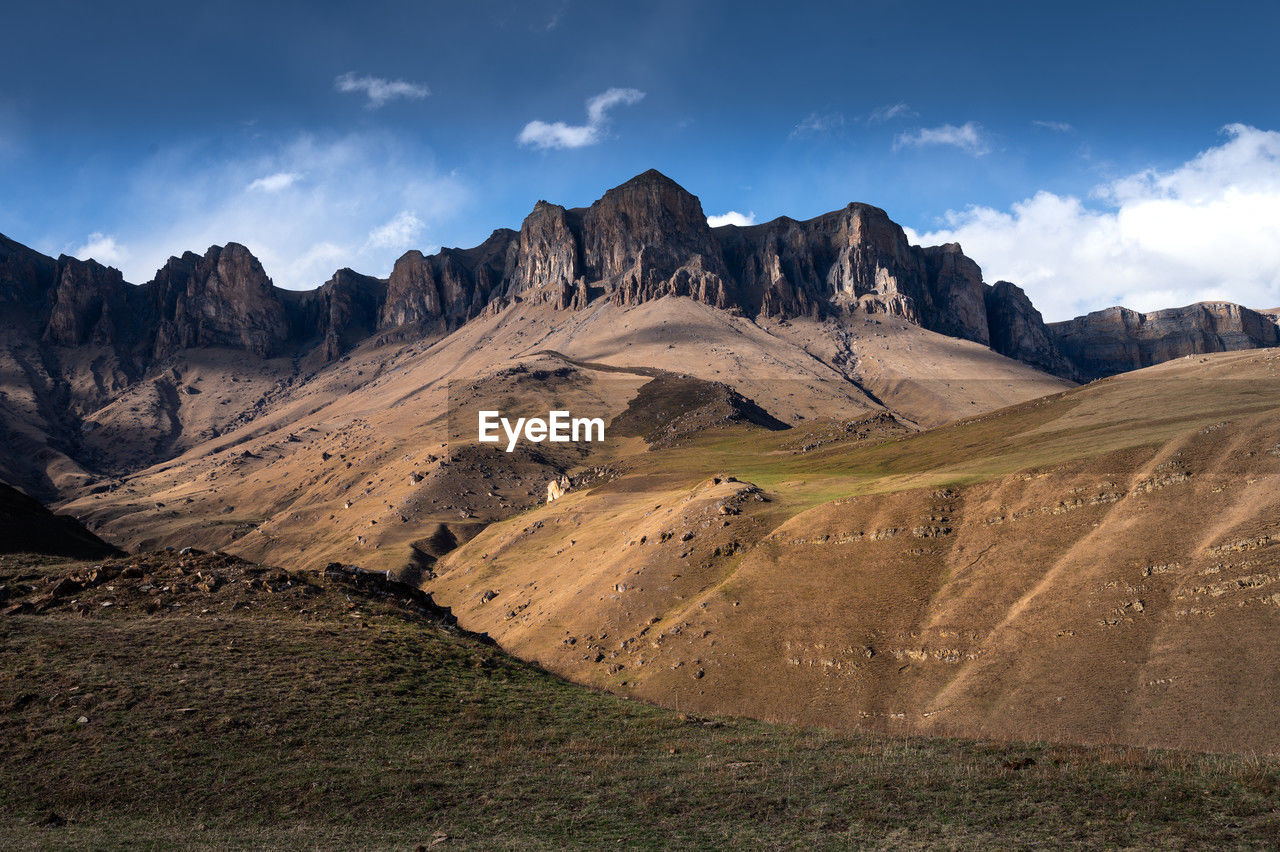 Off-road along the mountain range. beautiful mountains with autumn grass and colorful blue sky