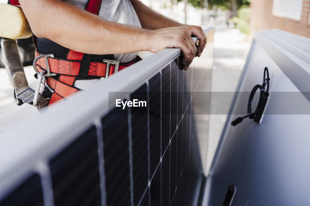 Close-up of electrician holding solar panel