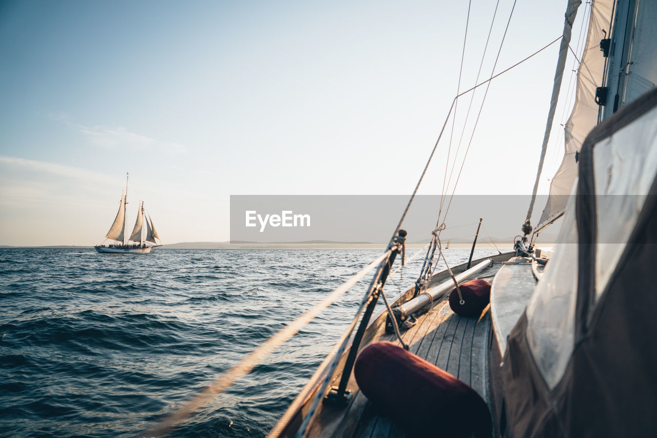 A schooner in maine bay viewed from another sailboat during late day