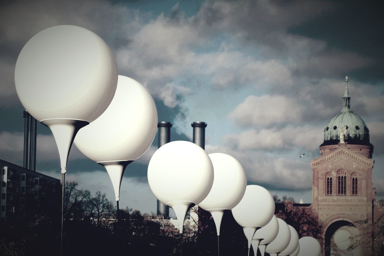 Close-up of round lights in rows against clouds
