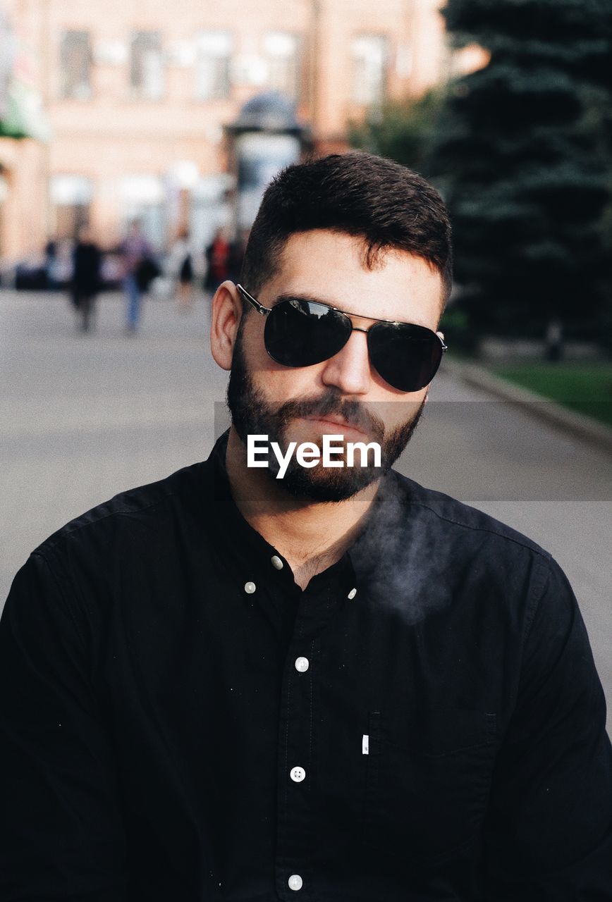 CLOSE-UP PORTRAIT OF MAN WEARING SUNGLASSES