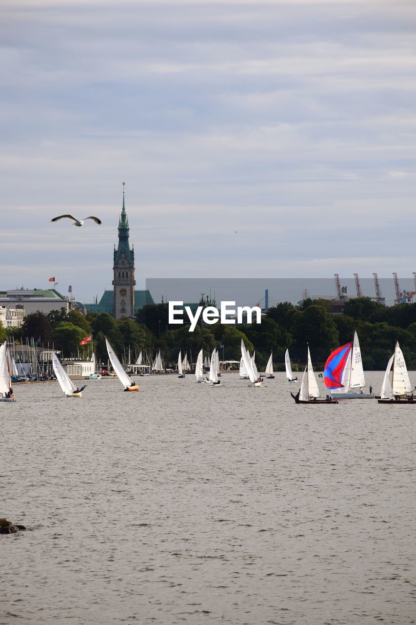 Sailboats in sea against sky