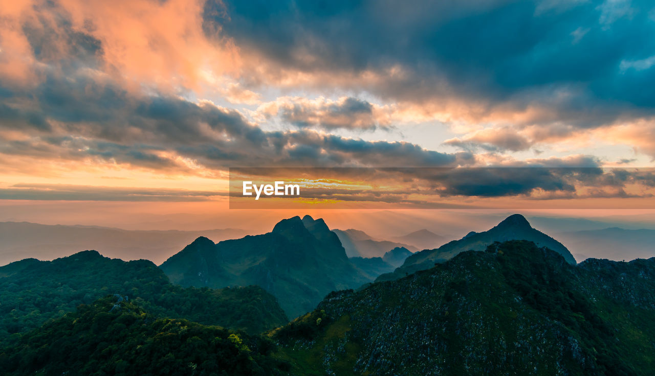 Beautiful mountain peaks topped with sky, cloud and blast horizon sun
