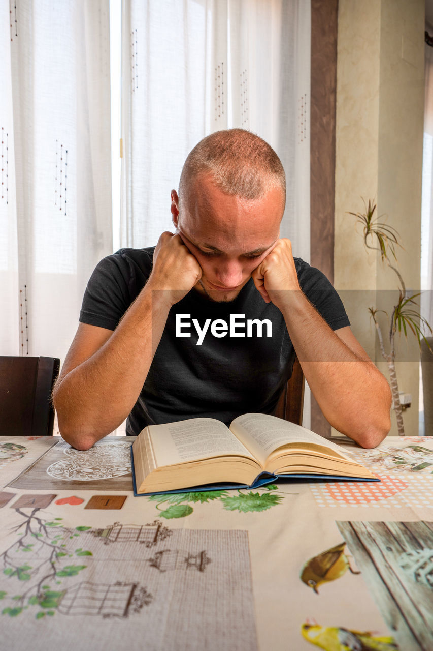 MAN SITTING ON TABLE