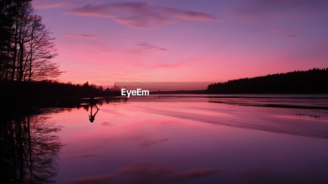 SCENIC VIEW OF LAKE AGAINST ORANGE SKY