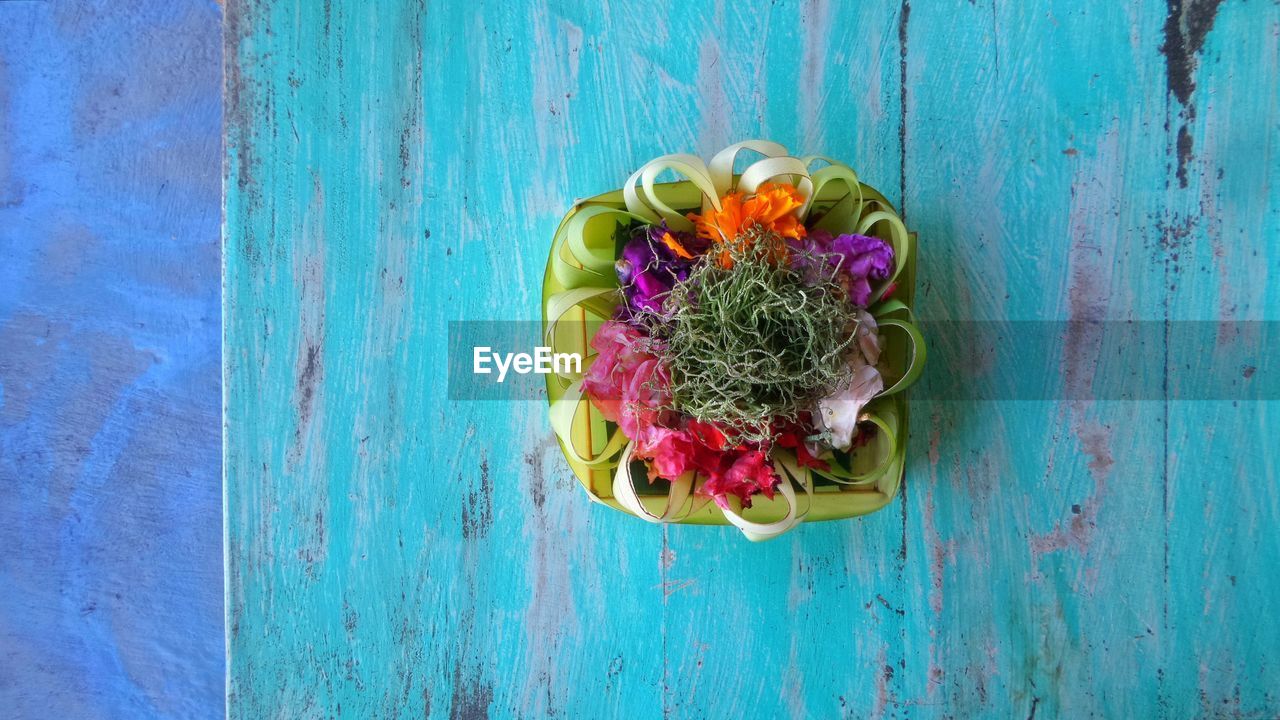 Directly above shot of religious offering on wooden table