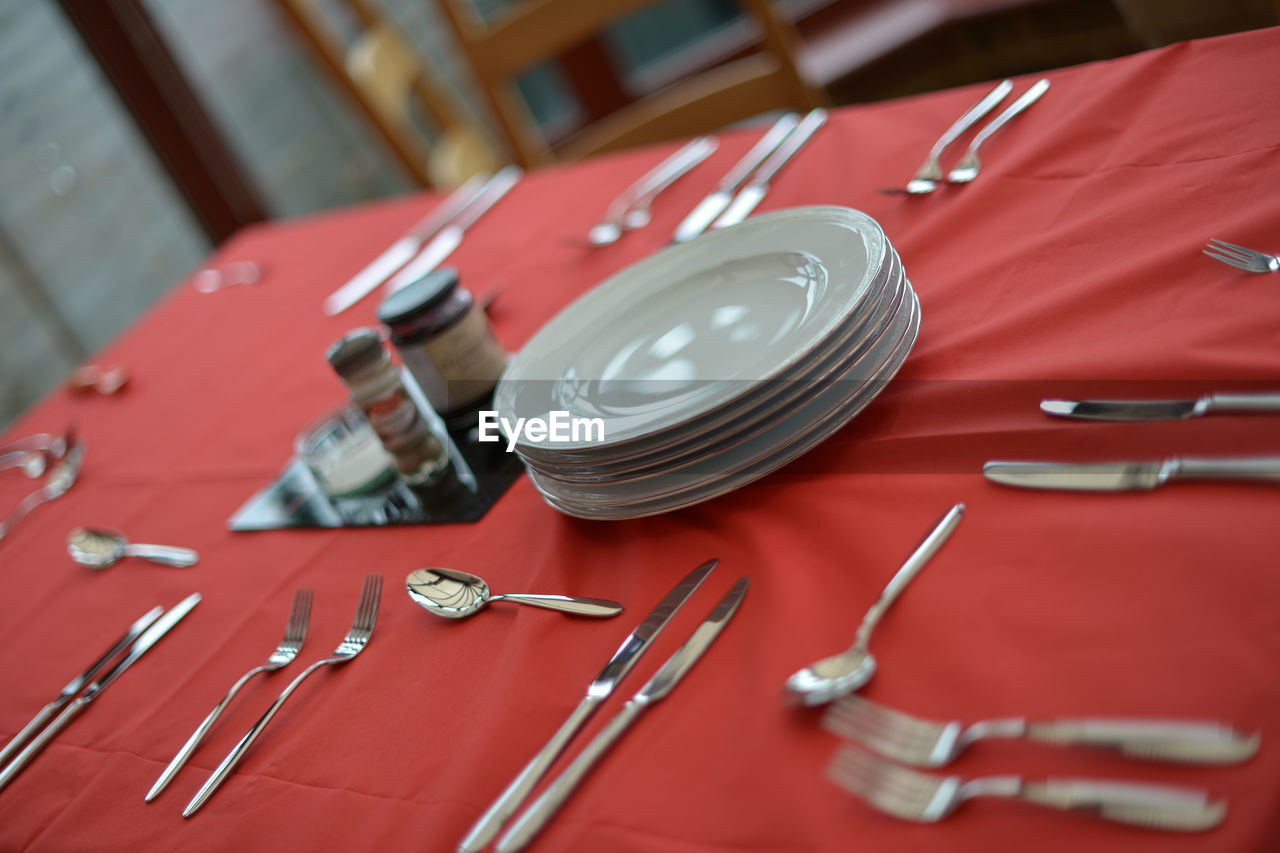 High angle view of plates and spoons arranged on table