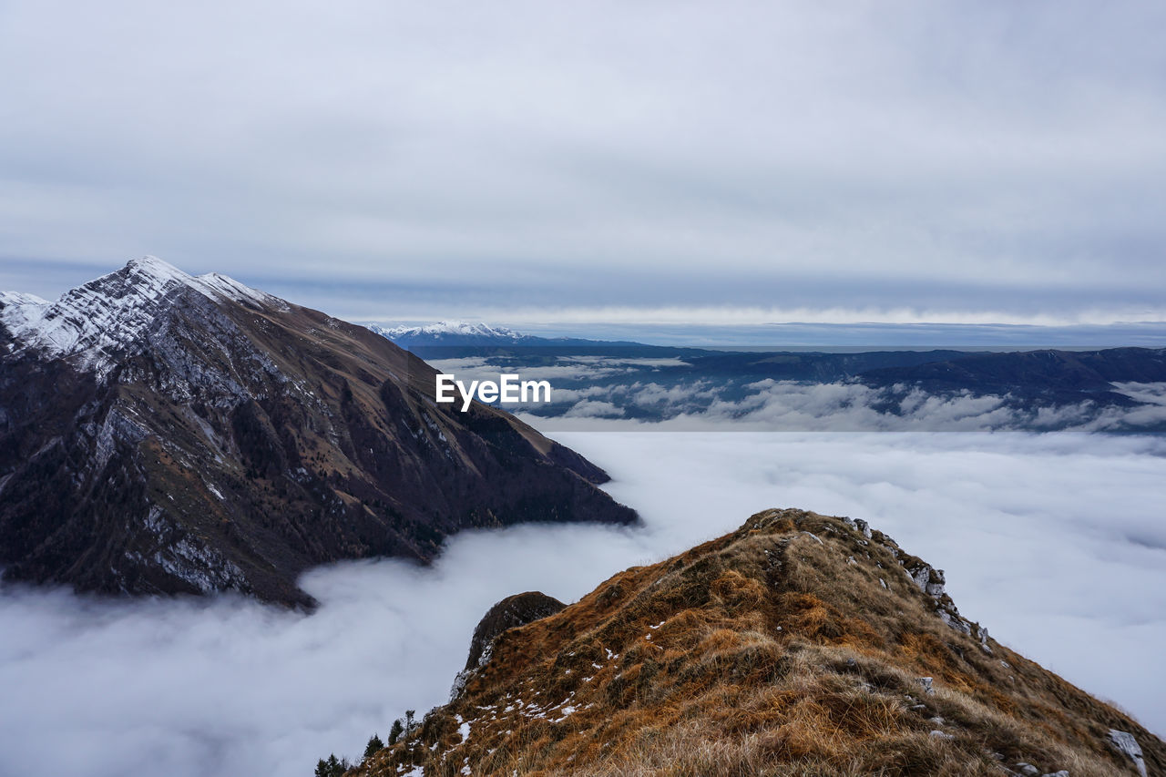 Scenic view of mountains against cloudy sky