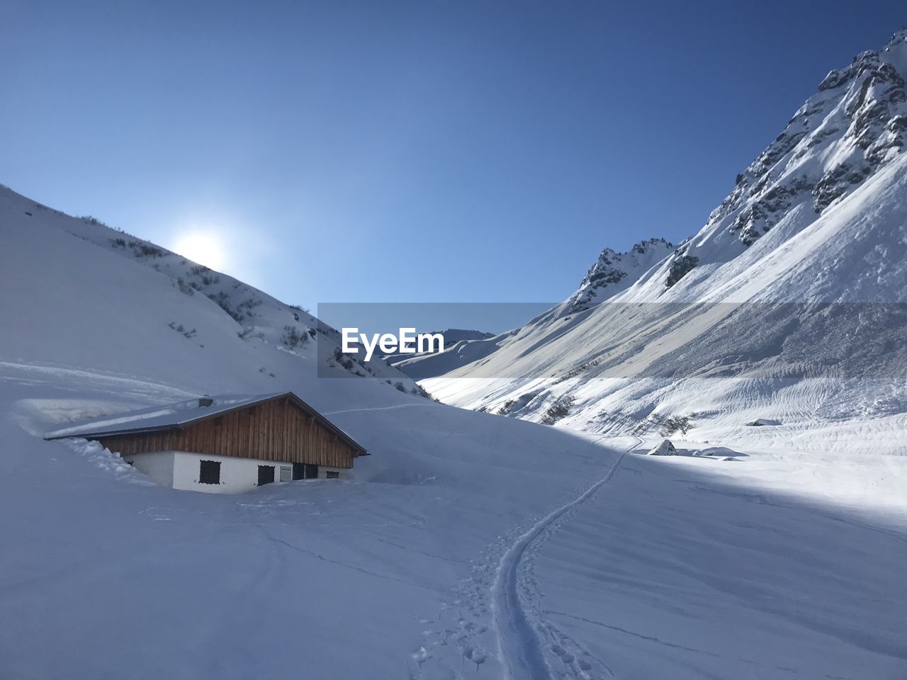 Scenic view of snowcapped mountains against clear blue sky