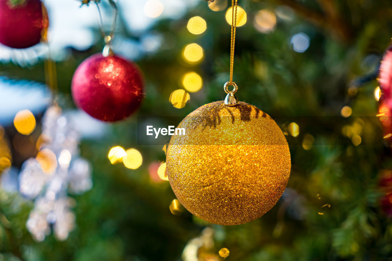 CLOSE-UP OF CHRISTMAS TREE HANGING ON BRANCH