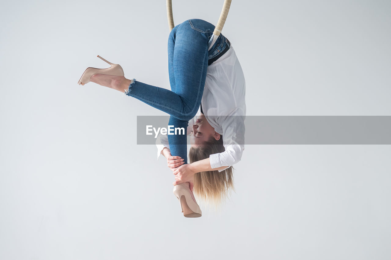 rear view of woman with arms raised standing against sky