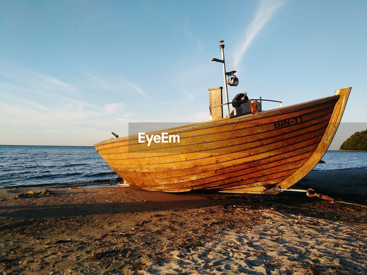 Boat moored on beach against sky