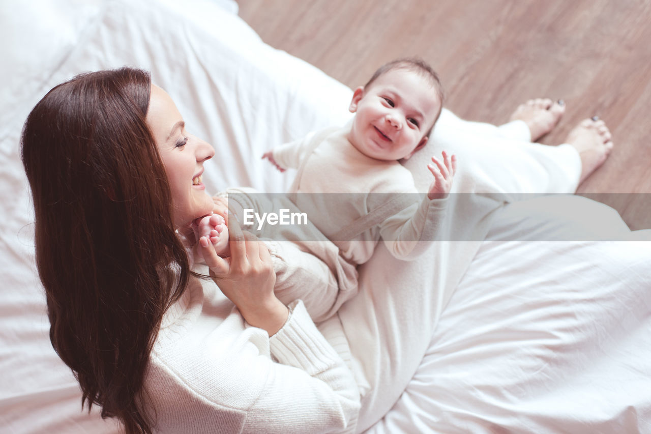 High angle view of mother and daughter lying on bed