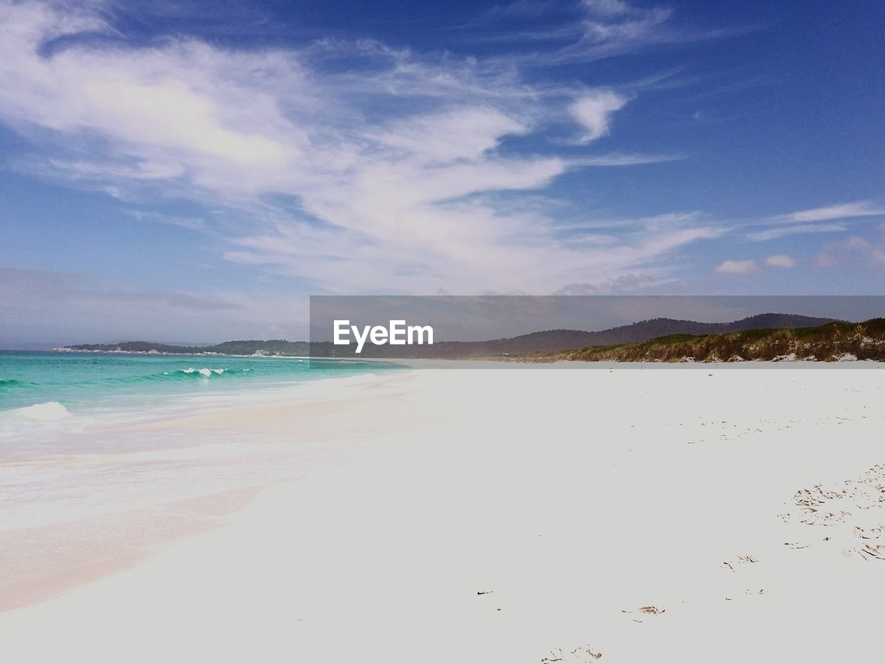 Scenic view of beach against cloudy sky