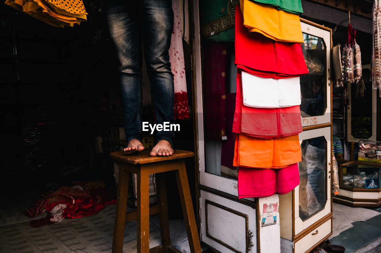 Low section of man standing on stool at market stall