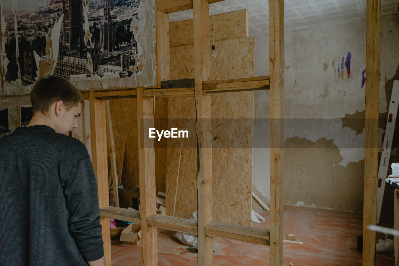 rear view of man standing in abandoned house