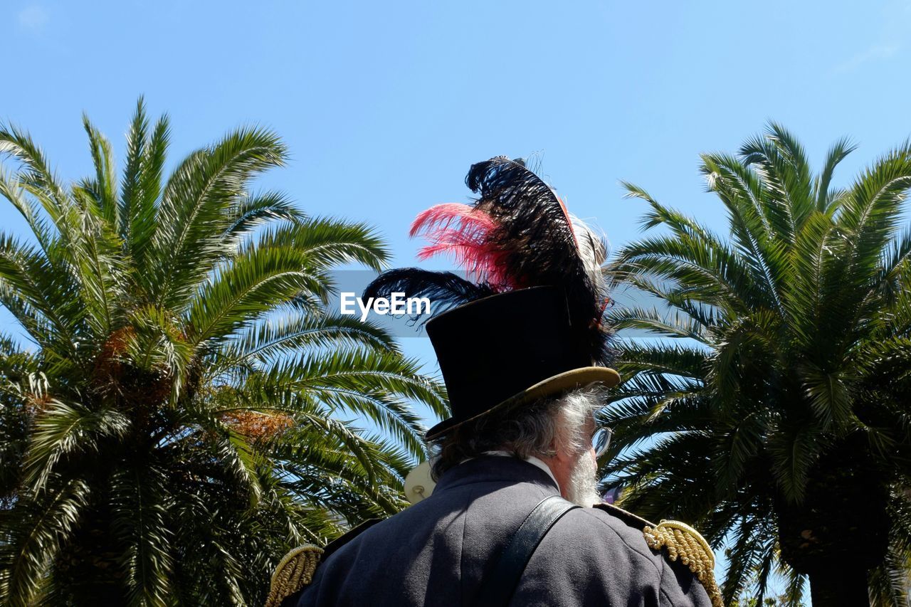 Rear view of man wearing feathers on hat