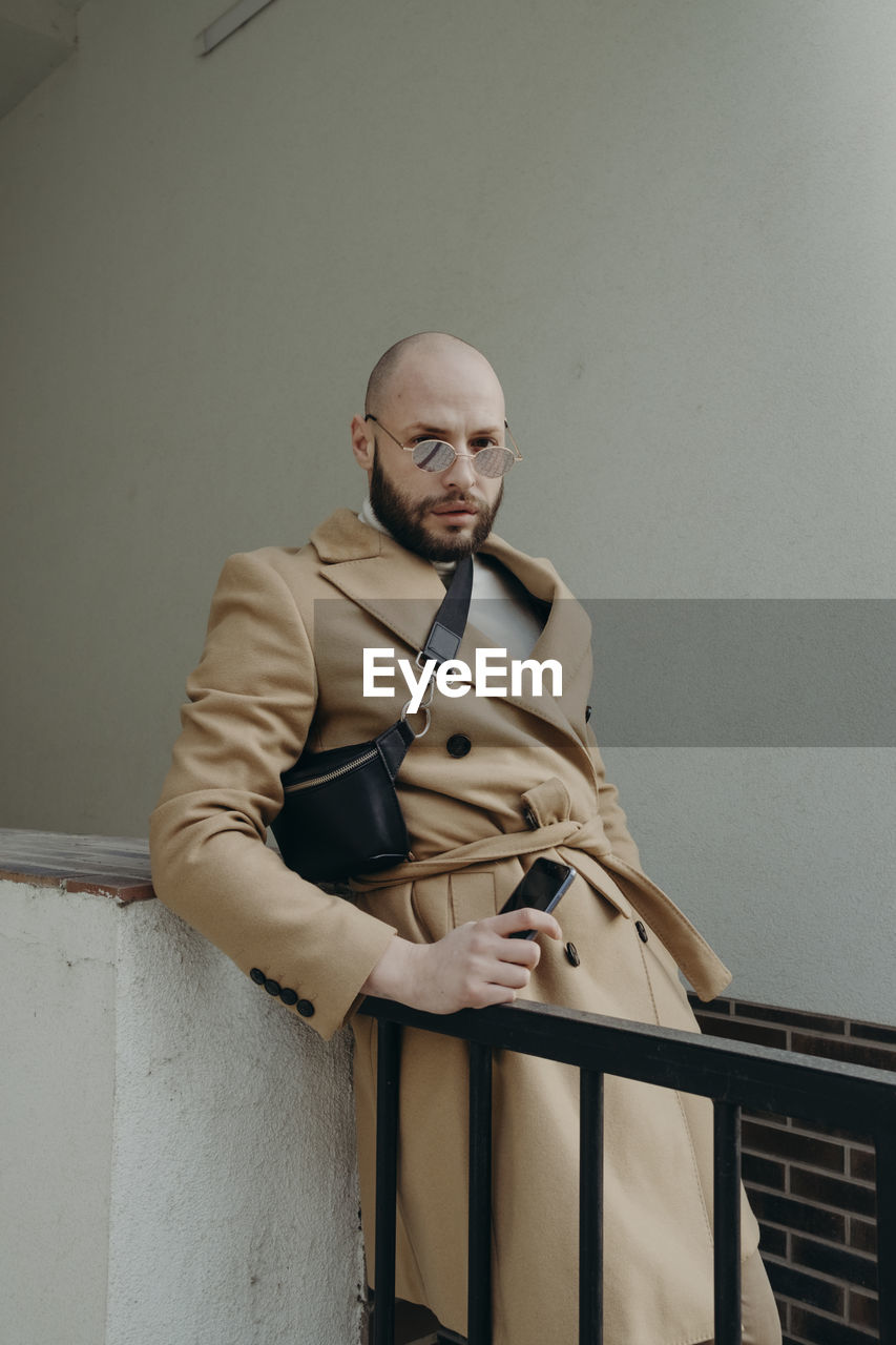 Portrait of man standing against wall