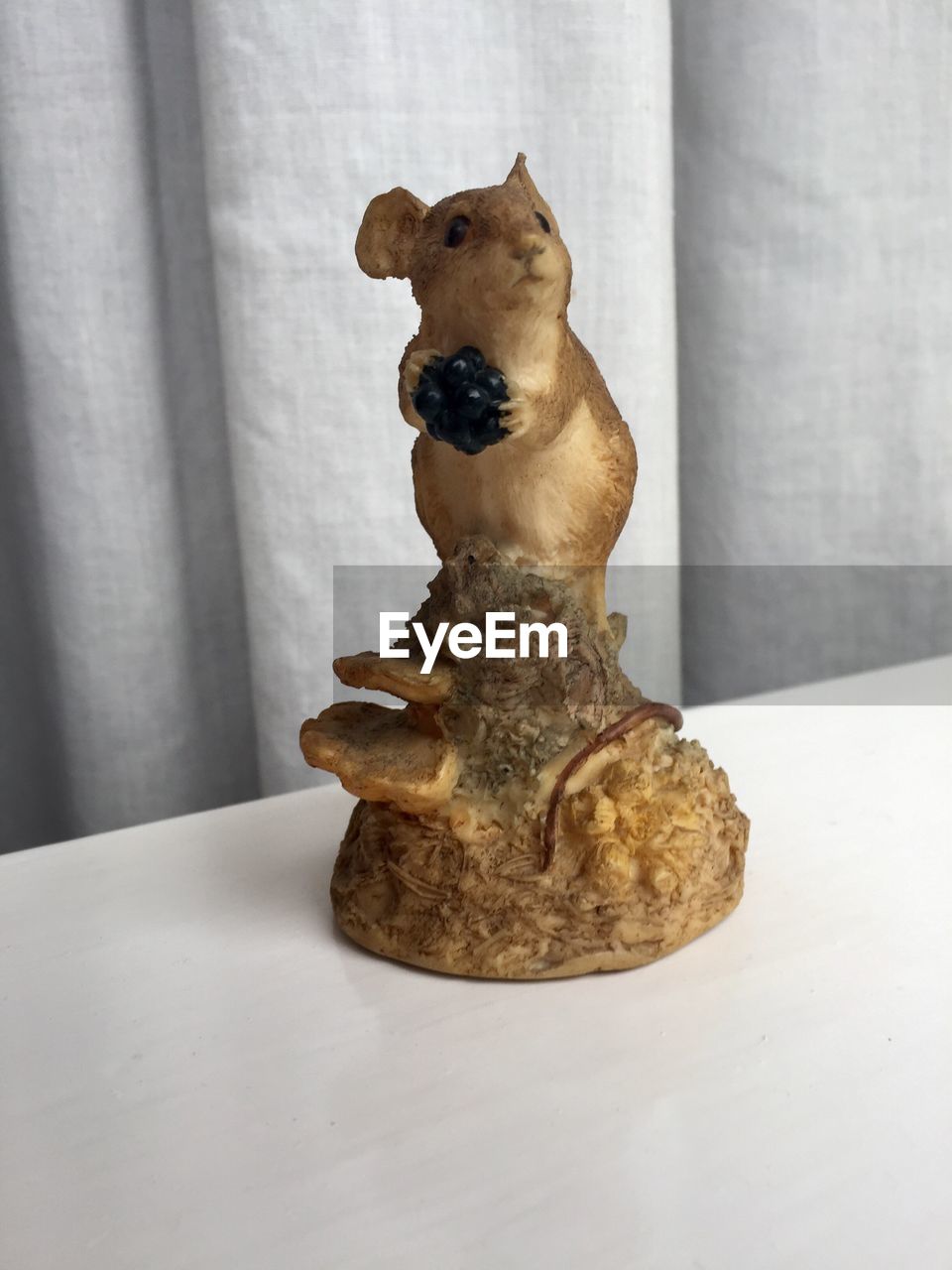 CLOSE-UP OF DOG WITH STATUE ON TABLE