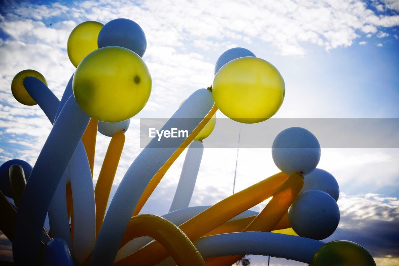 LOW ANGLE VIEW OF YELLOW BALLOONS AGAINST SKY