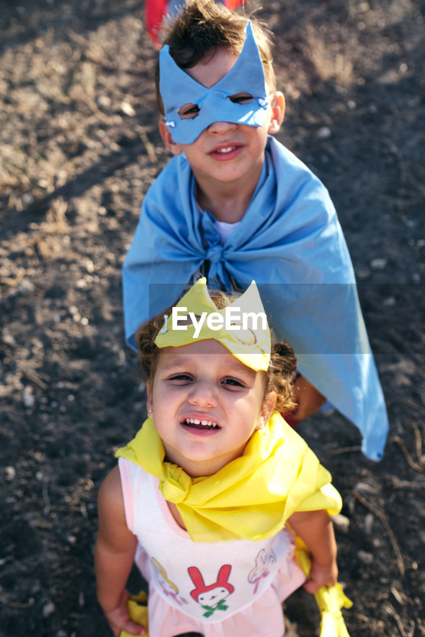 Children disguised as superheroes to play in the field, are watching o