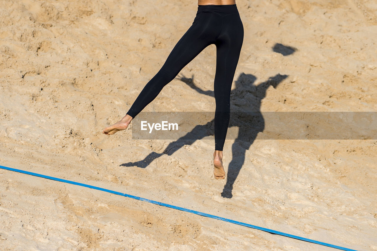 Low section of woman jumping on land