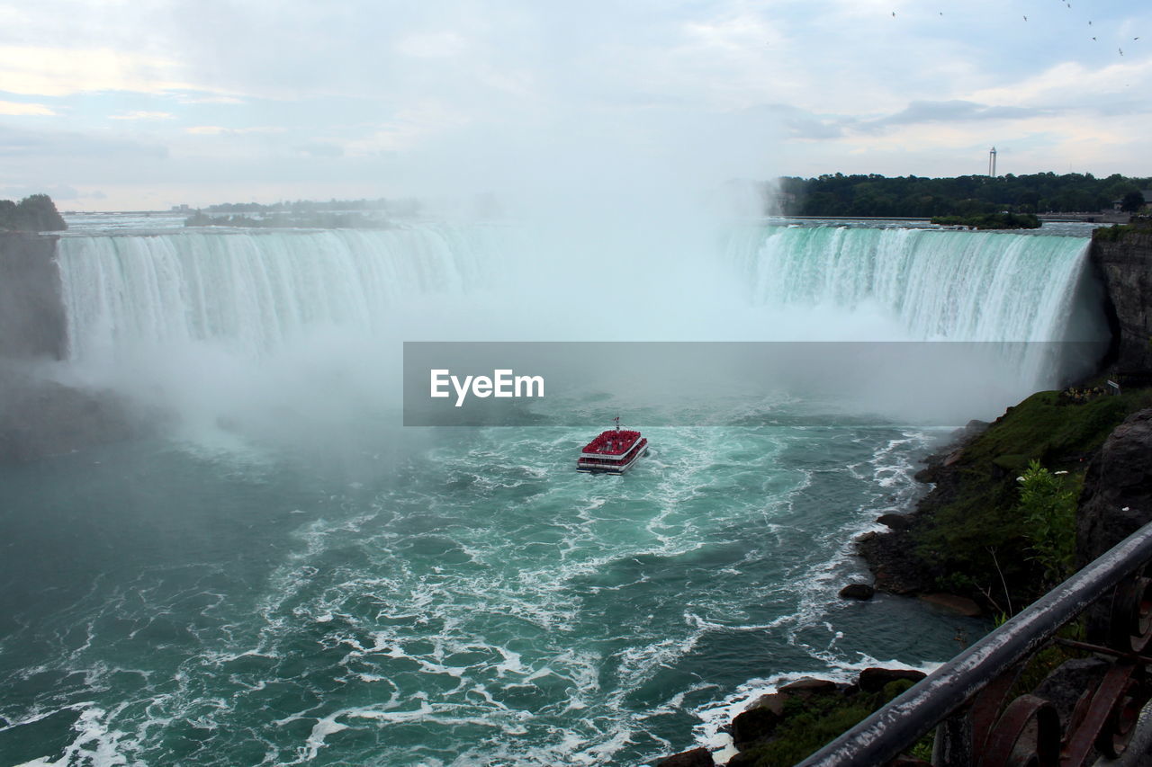 HIGH ANGLE VIEW OF WATERFALL AGAINST SKY IN BACKGROUND