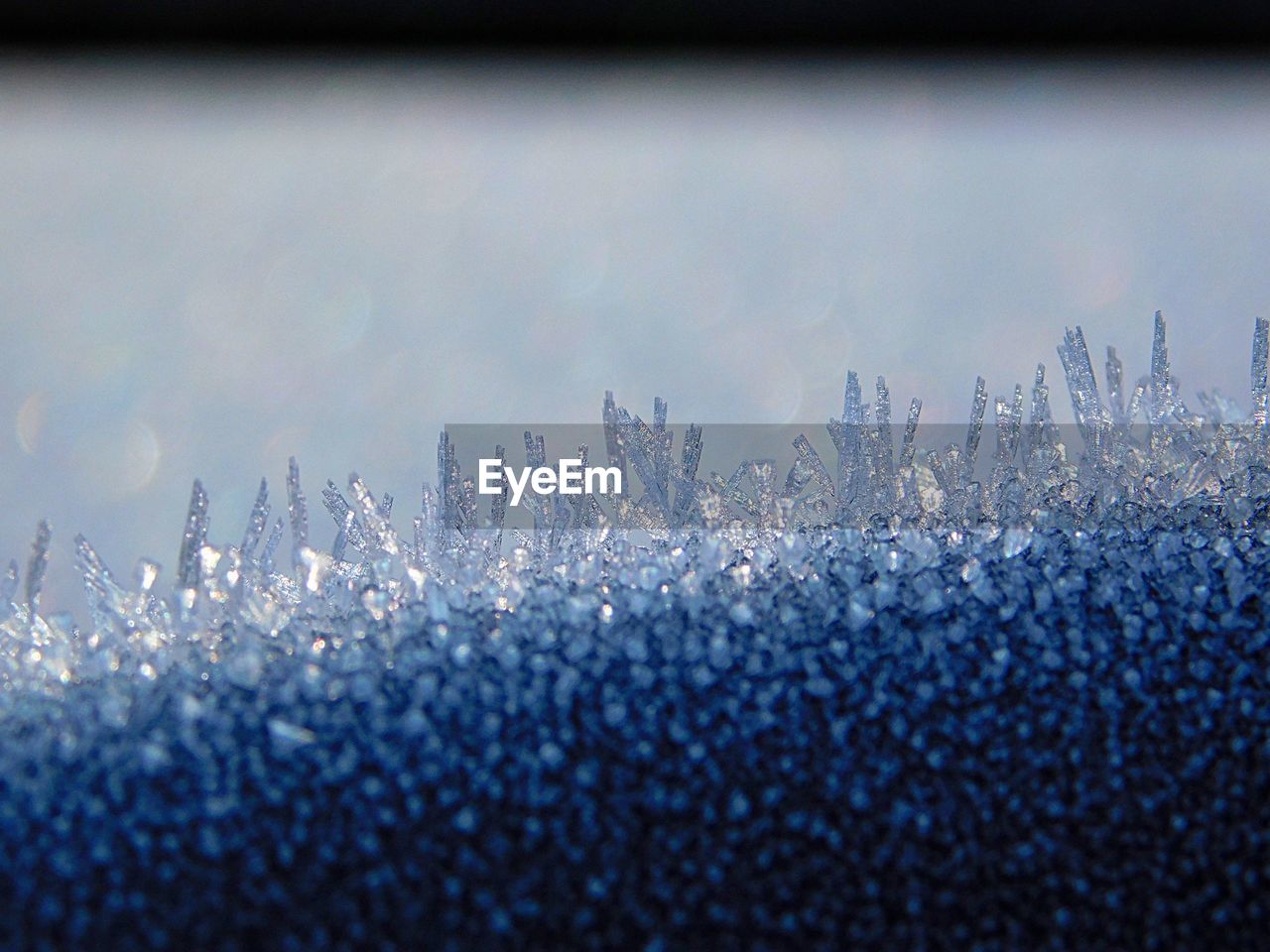 Close-up of water drops on window against sky