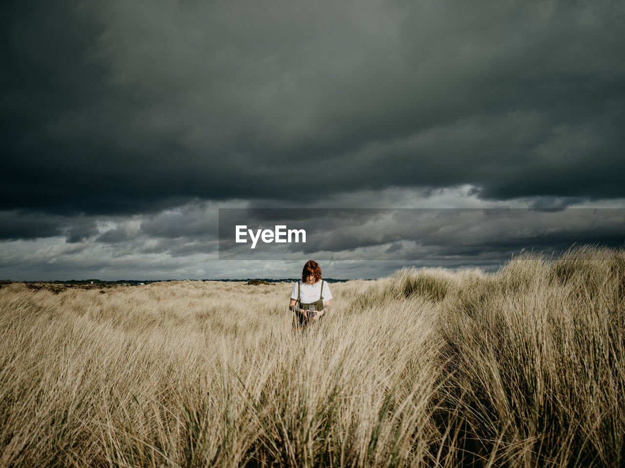 Woman standing on field against sky