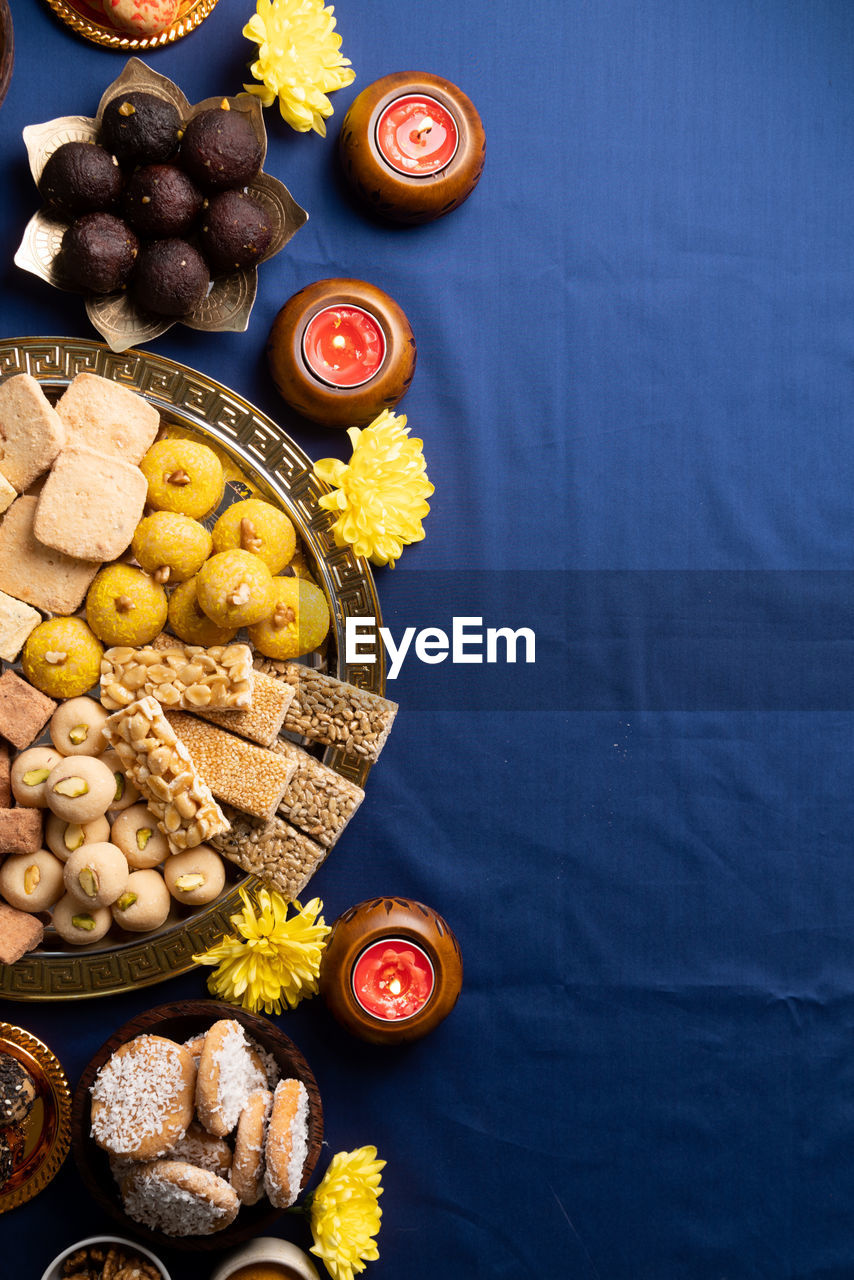 Indian traditional sweets laddu, soan papdi, burfi, gulab jamun for festival on blue background