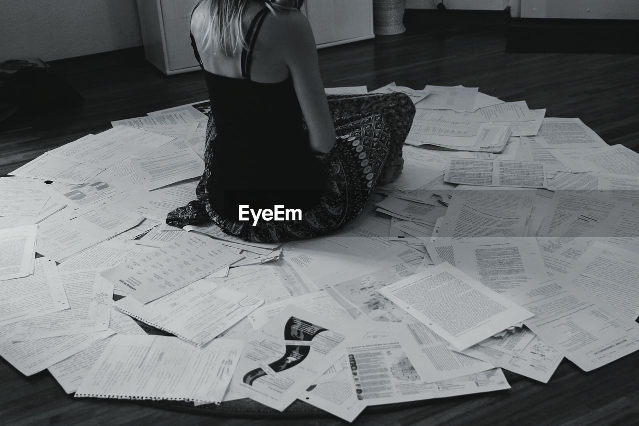 Hopeless woman surrounded by paperwork